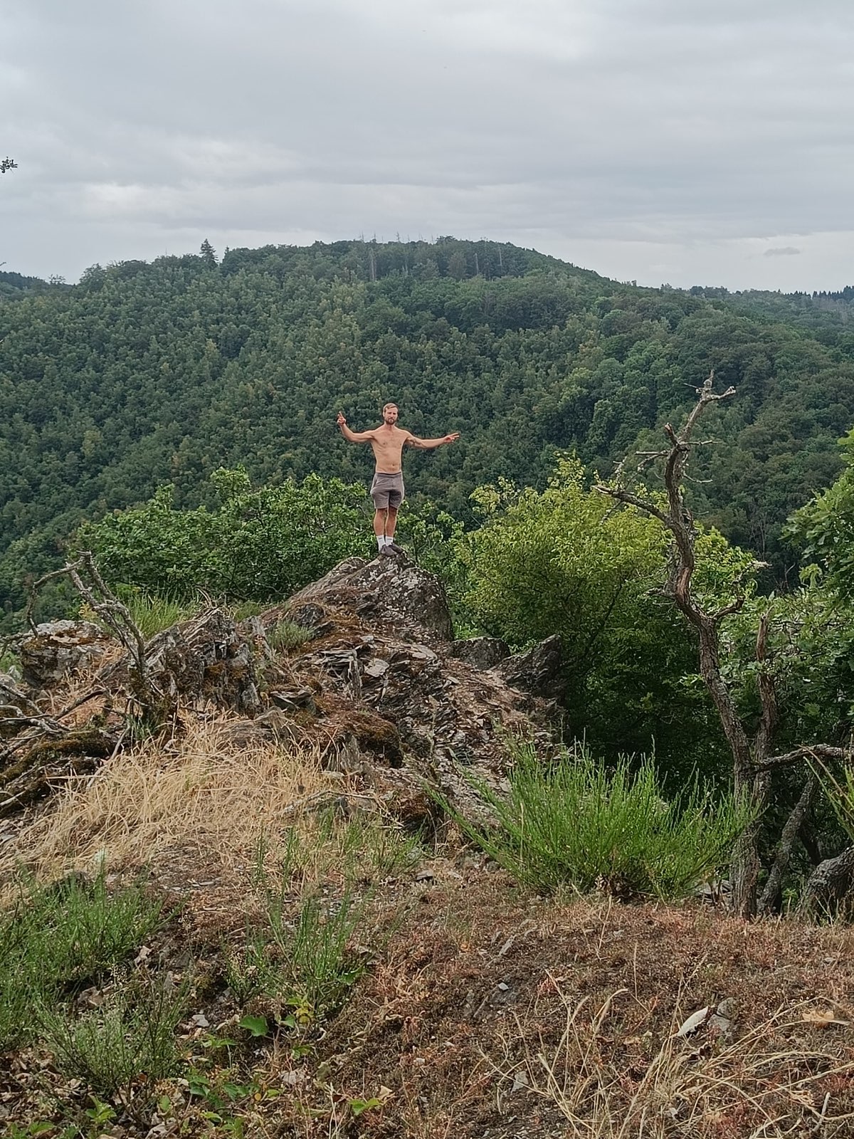 Fabian auf einem Felsen mit Blick über die Eifel